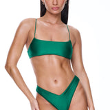 Woman wearing a green bikini set on a white background