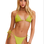 Woman wearing a green bikini set on a white background