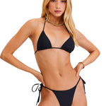 Woman wearing a black bikini set on a white background