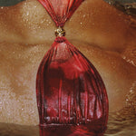 Red leather bag with a gold clasp on a textured surface