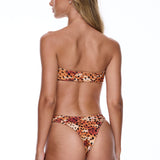 Woman wearing a leopard print bikini on a white background
