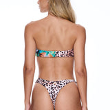 Woman wearing a leopard print bikini on a white background