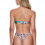Woman wearing a leopard print bikini on a white background