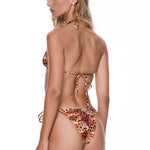 Woman wearing a leopard print bikini on a white background